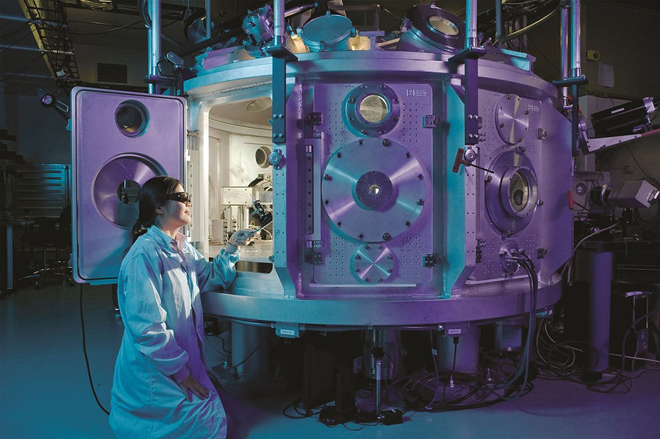 Scientist in lab coat inspecting content inside a pressure tank.